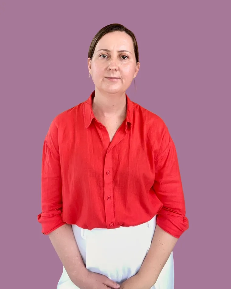 Kylie Gillin in a red shirt against a dusty mauve background.